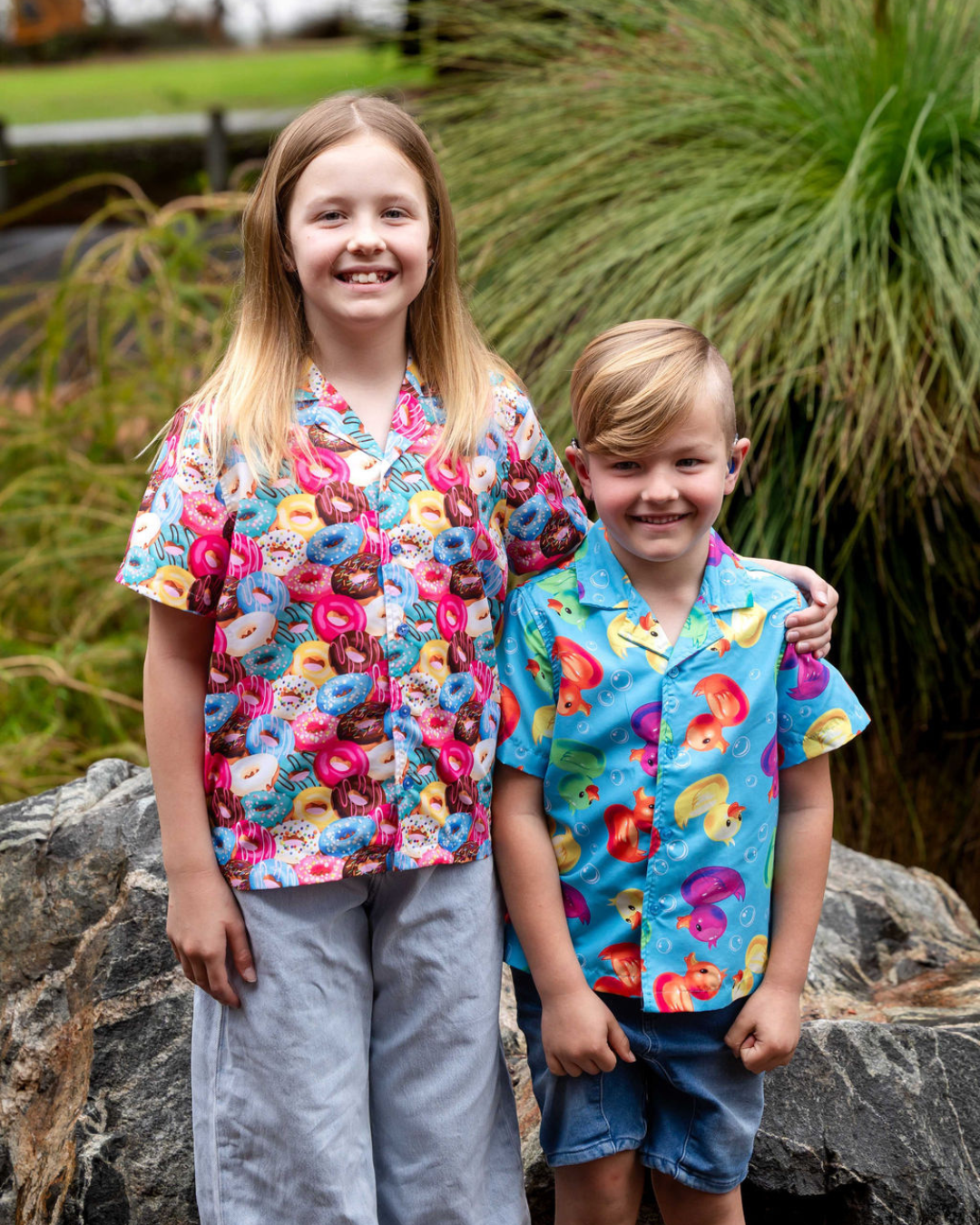 Two children in loud shirts smiling to camera Two children in loud shirts smiling to camera