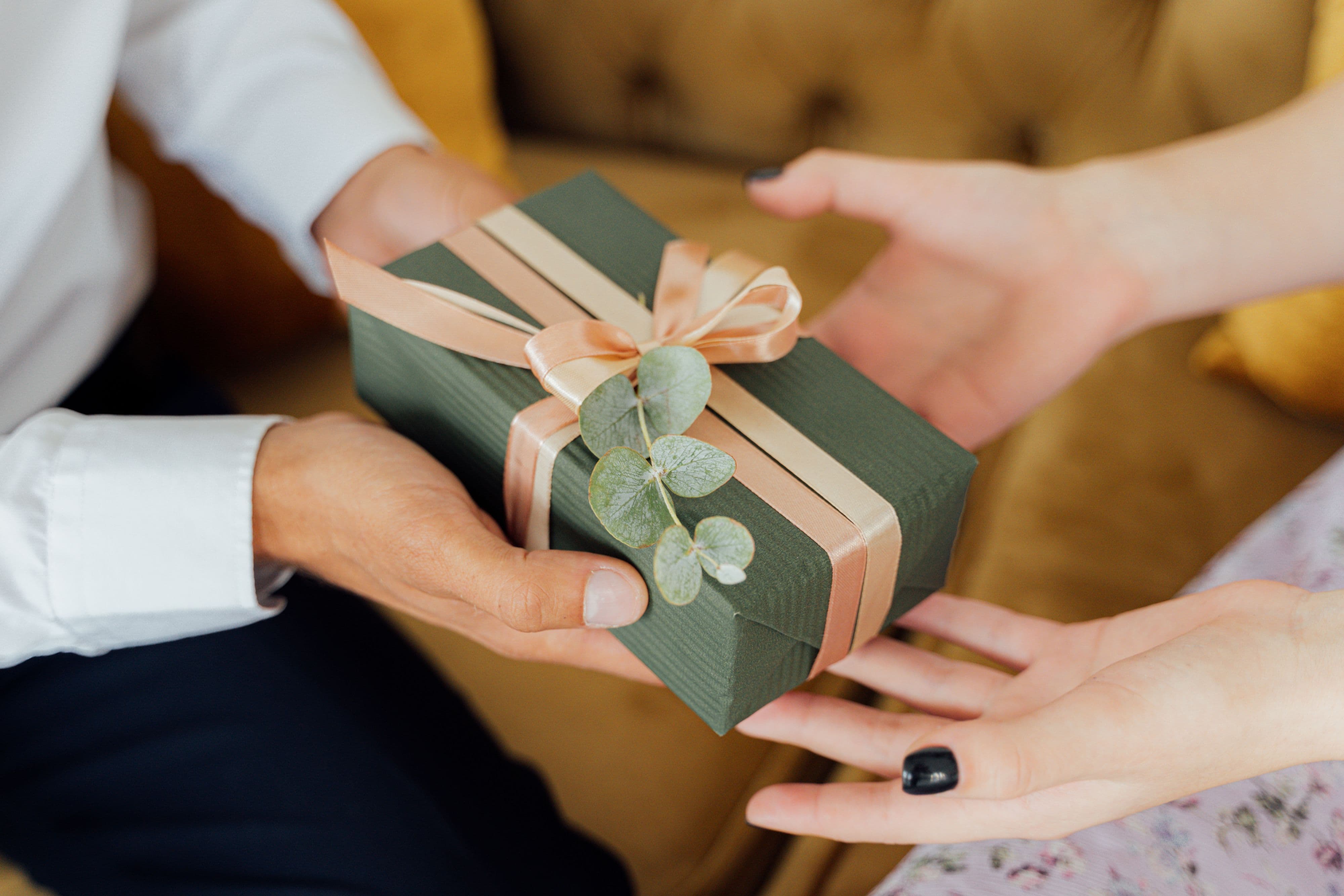man giving a gift wrapped in green paper